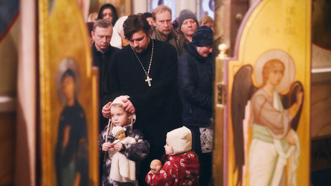 priest with family in church